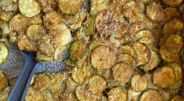 Fette di zucchine al forno semplici light, dorate e croccanti, pronte per essere gustate.