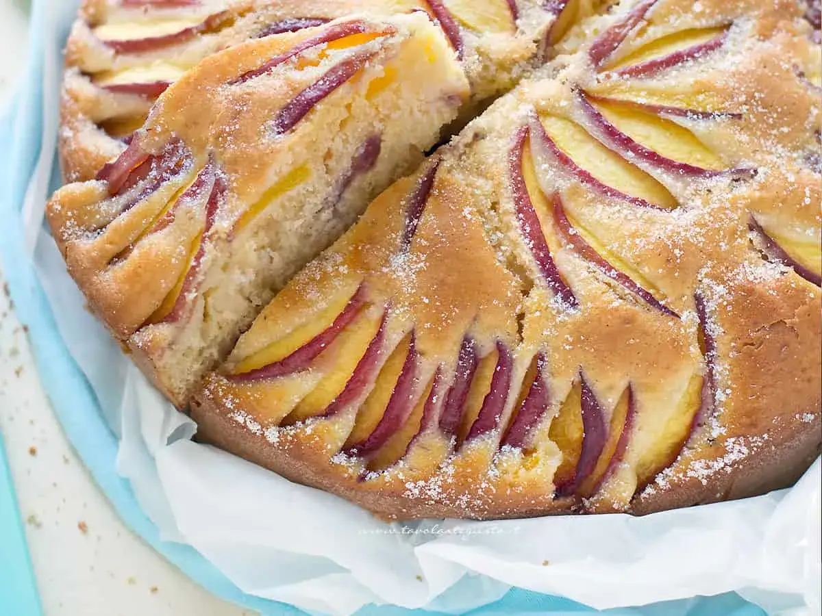Torta alle pesche della nonna, soffice e profumata, con fette di pesca disposte a raggiera sulla superficie dorata.