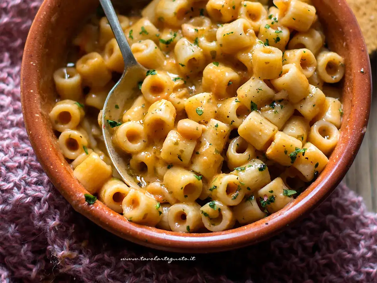 Una ciotola di pasta e fagioli in scatola cremosa, condita con prezzemolo fresco. Un piatto confortante e veloce.