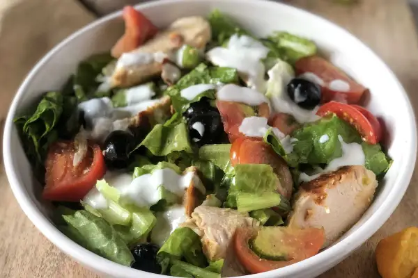 Insalata di pollo sfiziosa con lattuga croccante, pomodoro, olive nere e un dressing cremoso. Perfetta per un pasto leggero e gustoso.