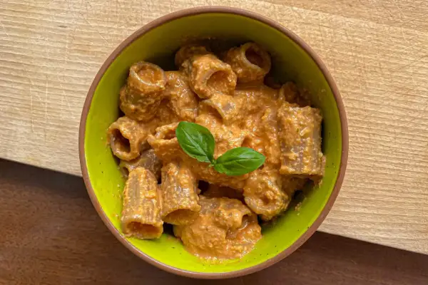 Rigatoni conditi con un cremoso pesto con mandorle, guarniti con basilico fresco.